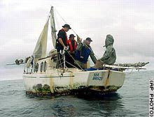 
In this U.S. Navy photo, sailors from the McClusky speak to a parka-wearing Van Pham, right, 
aboard his sailboat after he was found adrift.